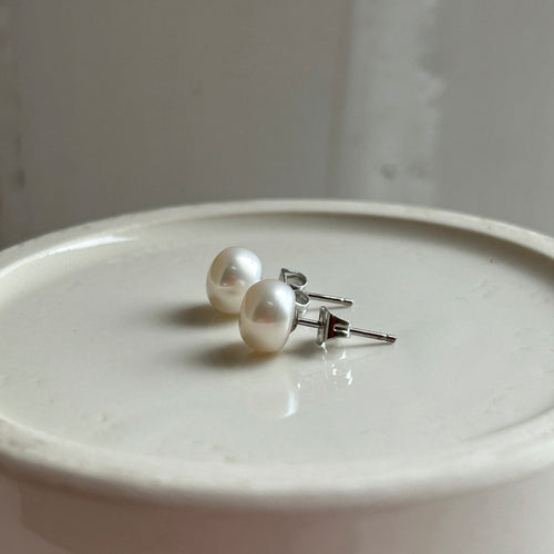 Pearl earrings with small white cultured freshwater near round studs on surgical steel posts