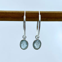 Gemstone earrings with aquamarine (blue) oval crystal drops on silver medium hoops