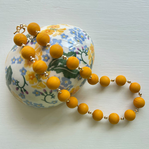 Necklace with matt yellow ochre pastel Murano glass small sphere beads on gold beads and clasp