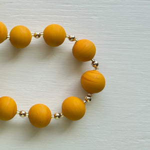 Necklace with matt yellow ochre pastel Murano glass small sphere beads on gold beads and clasp