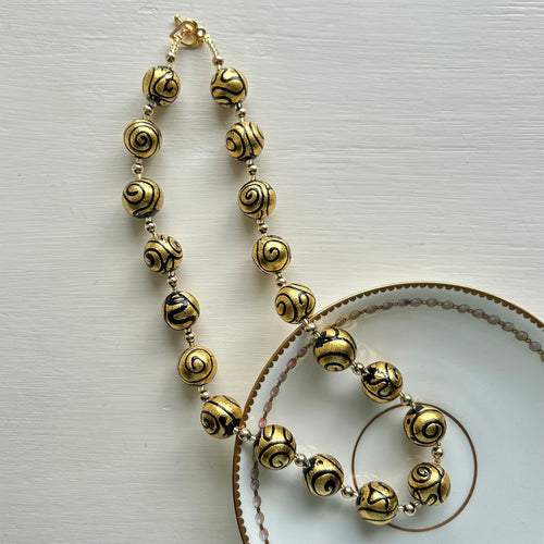 Necklace with black pastel appliqué Aztec over gold Murano glass sphere beads on gold