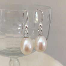 Pearl earrings with medium freshwater natural white oval pearl drops on silver hooks