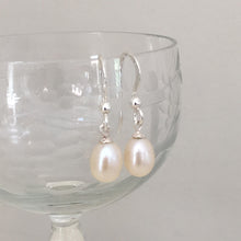 Pearl earrings with small freshwater natural white oval pearl drops on silver hooks