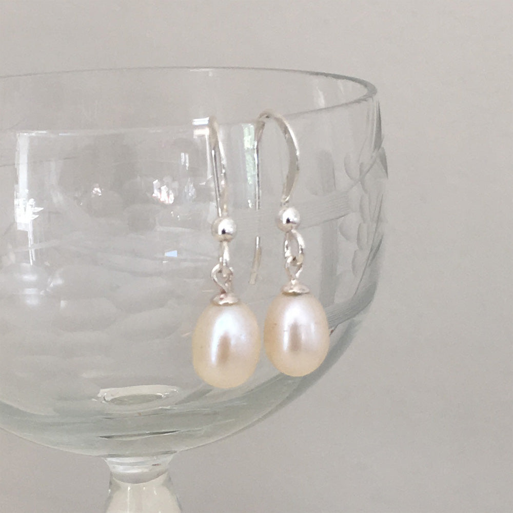Pearl earrings with small freshwater natural white oval pearl drops on silver hooks