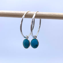 Gemstone earrings with turquoise (blue) oval crystal drops on silver medium hoops