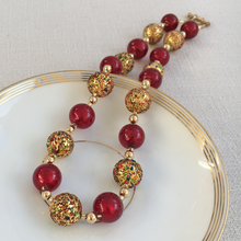 Necklace with speckled colours and red Murano glass sphere beads on gold
