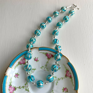 Necklace with turquoise (blue) appliqué over white gold Murano glass sphere beads on silver