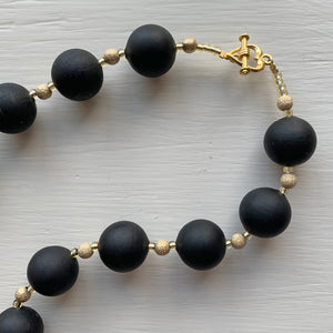 Necklace with matt black Murano glass small sphere beads on gold stardust beads and clasp