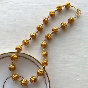 Necklace with gold topaz appliqué over gold Murano glass sphere beads on gold