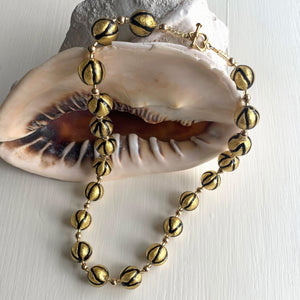 Necklace with black pastel drizzle and gold Murano glass sphere beads on gold
