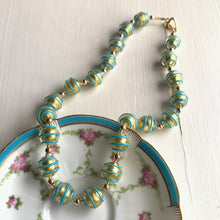 Necklace with turquoise (blue) pastel appliqué spiral over gold Murano glass sphere beads on gold
